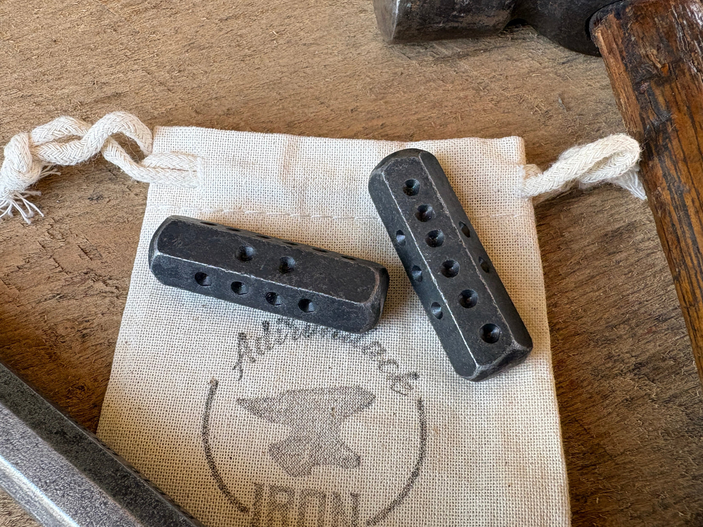 Hand forged iron hex dice on a muslin gift bag labeled adirondack iron