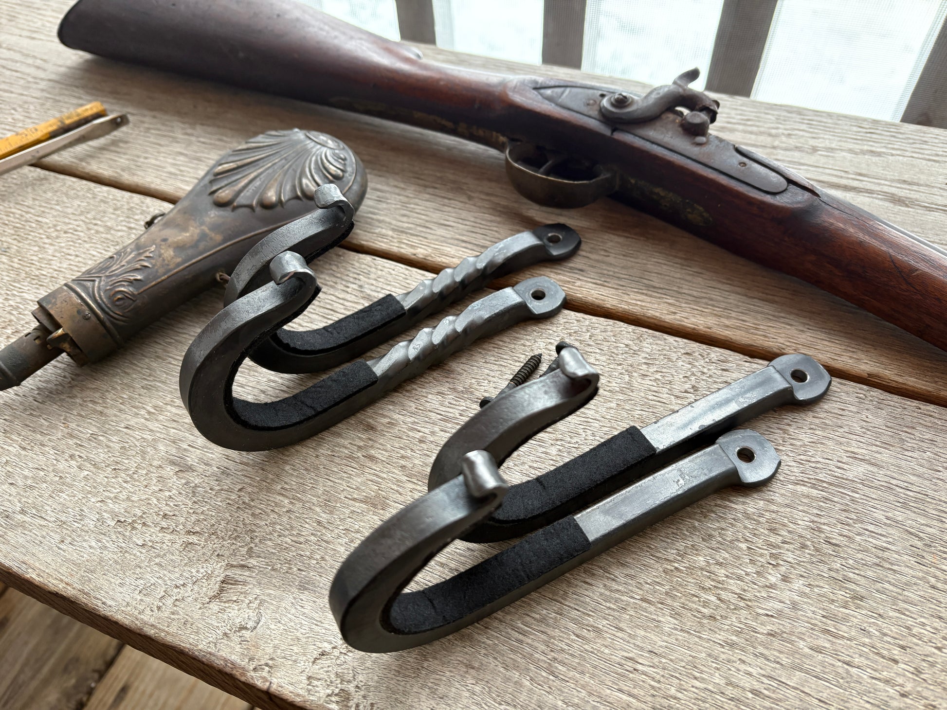 two different styles of hand forged rustic gun hooks, twisted and straight