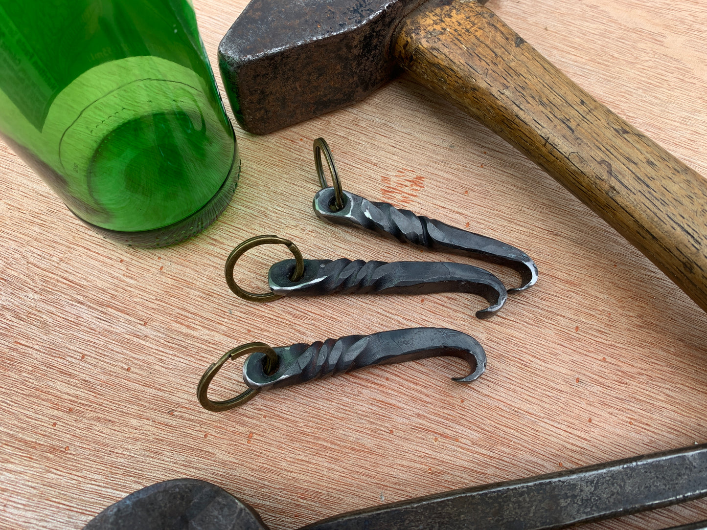 three hand-forged bottle openers